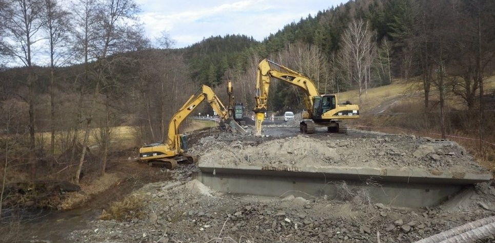 Na silnici mezi obcemi Cihelny a Kfely probíhá demolice mostu přes řeku Teplá.